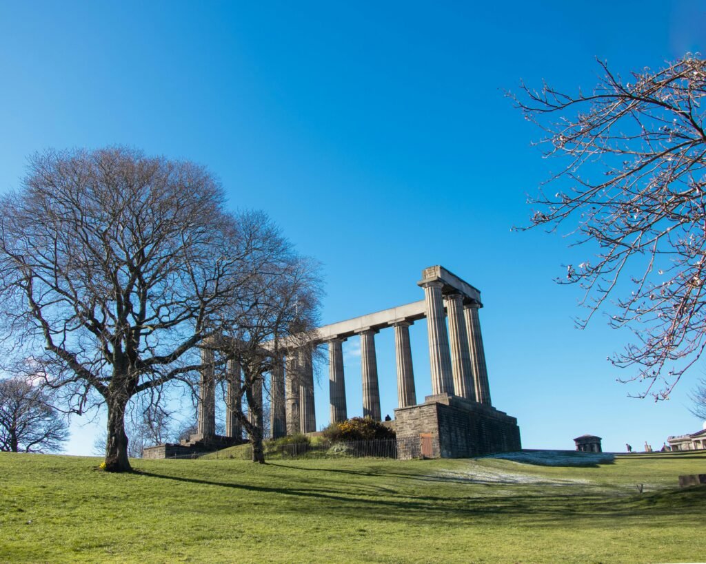 Scenic view of the National Monument on Calton Hill under a clear blue sky in Edinburgh, Scotland.